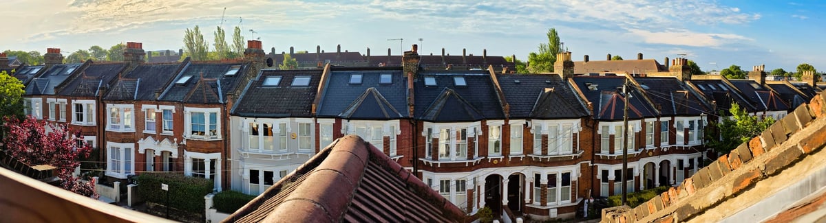 Rooftop view of traditional red brick Victorian terraced houses with chimney stacks in a British town